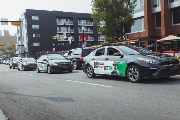 Bet99 branded rideshare vehicles drive downtown Calgary